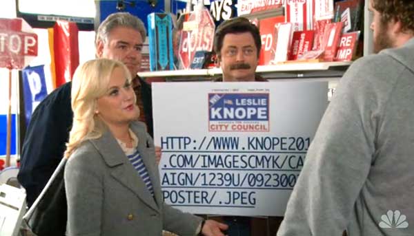 Кадр из сериала NBC "Парки и зоны отдыха". Герой Рон Суонсон (Ron Swanson) держит плакат "Knope for City Council" (Ноуп в Городской совет), большую часть которого занимает длинный и сложный URL-адрес. Лесли Ноуп отвечает: "Как вы понимаете, мы никогда бы не заказали плакат с этой абракадаброй, мы ведь не сумасшедшие."