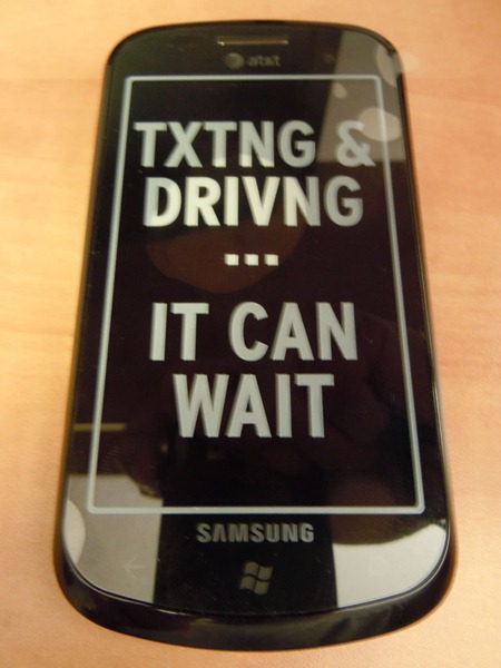 Front of Samsung Focus phone, with "TXTING & DRIVNG...IT CAN WAIT" sticker