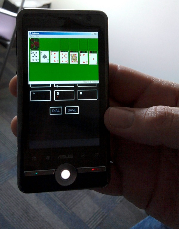 Мобильный телефон с игрой "Косынка", открытой в окне поверх телефонной клавиатуры