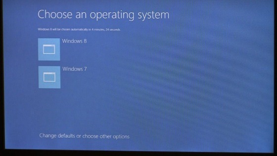 Экран с вариантами загрузки в Windows 8: "Выберите операционную систему" значок 1: Windows 8; значок 2: Windows 7; ссылка "Изменить значения по умолчанию или выбрать другие параметры"