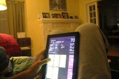 A person sitting on a couch using a tablet in portrait mode