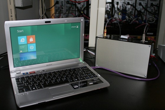 Ноутбук, который работает под управлением Windows 8 и подключен к устройству, измеряющему энергопотребление