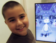 Adrian Ruiz plays with an interactive robot during a visit to Alex's Place.
