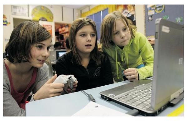 Three Students at St. Mary Catholic Elementary School programming with Kodu.