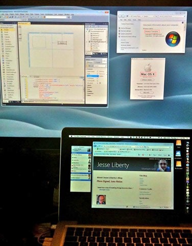 A MacBook Pro standing in front of a Cinea Display monitor, showing both Windows 7 and Mac OS X.